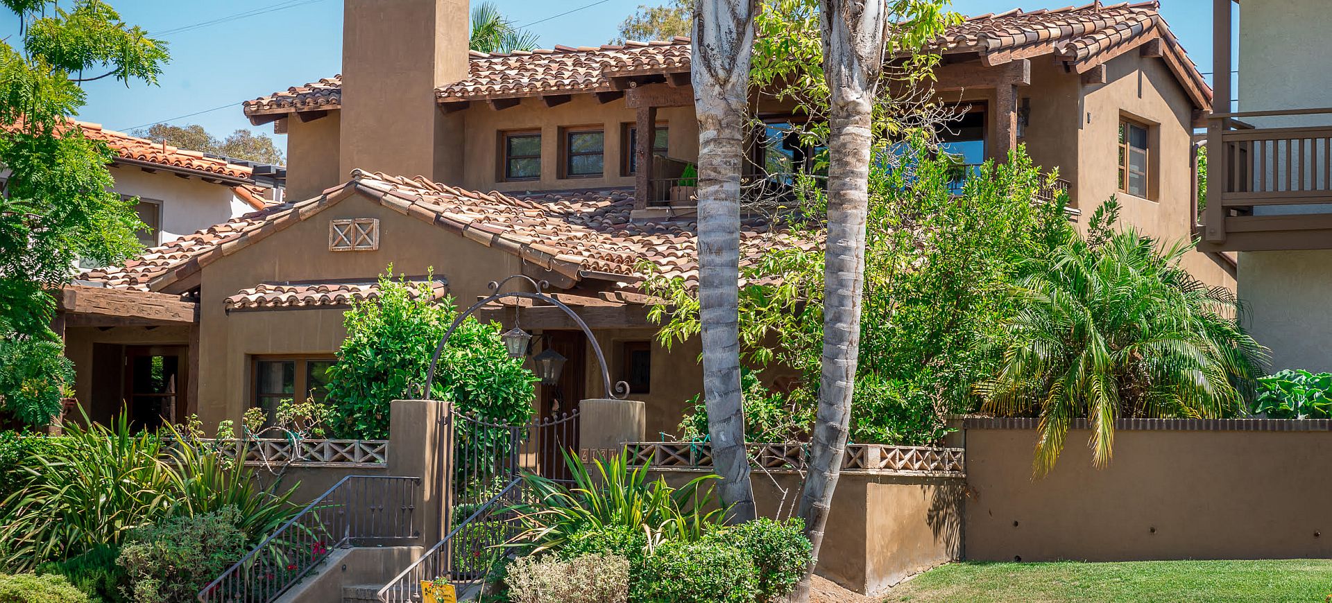 Spanish colonial home with tile roof, stucco and mature planting in Rancho Santa Fe