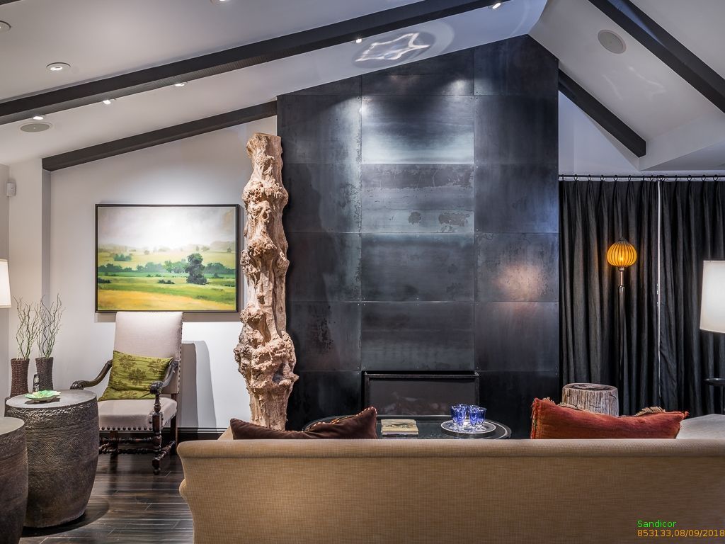 Staged living room with fireplace, art and layered lighting